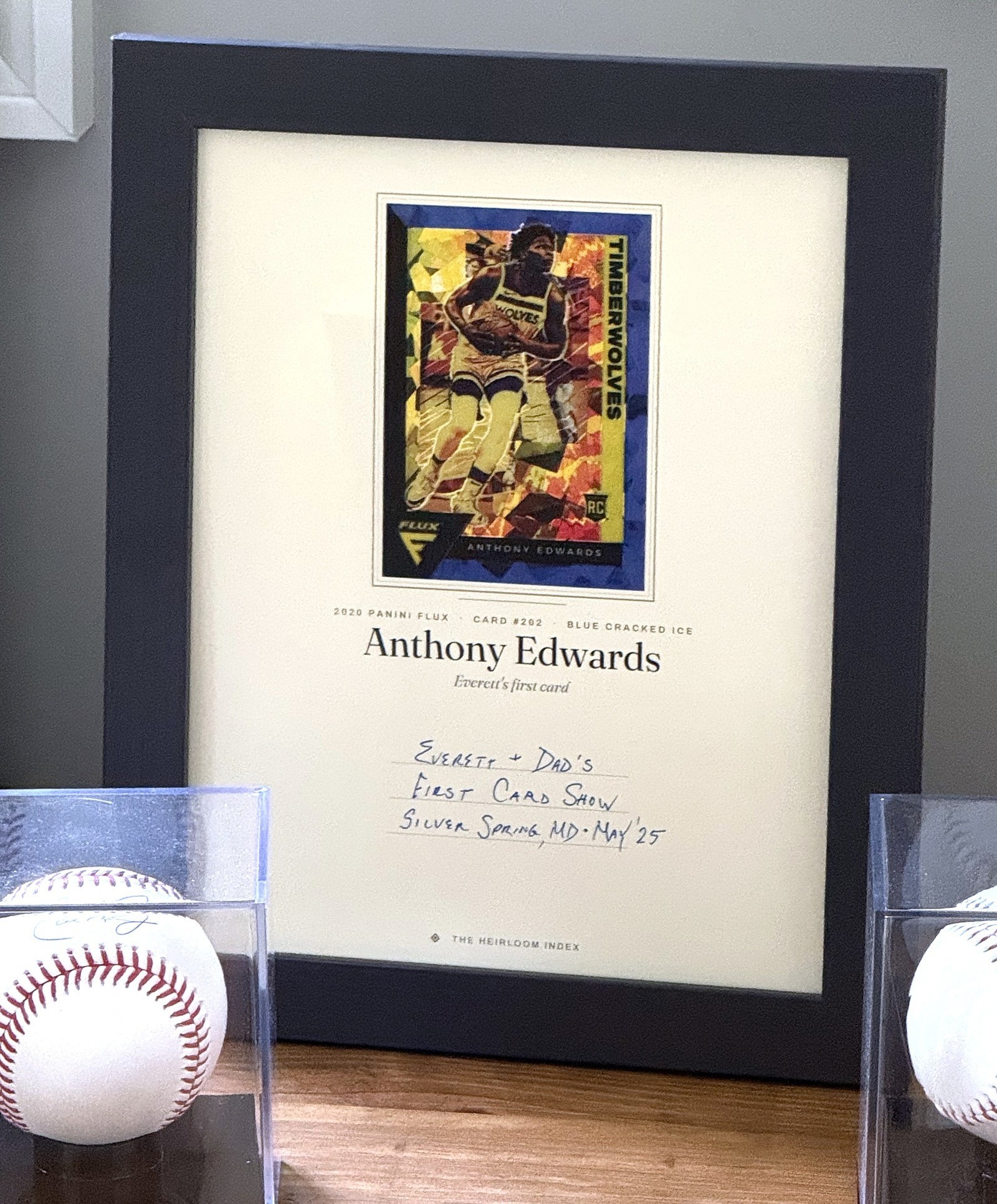 A framed print of a 2020 Panini Flux Anthony Edwards rookie card, captioned “Everett’s first card”, with a handwritten note beneath it recording the card show where it was found